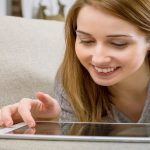 A person sitting in a chair looking at a tablet